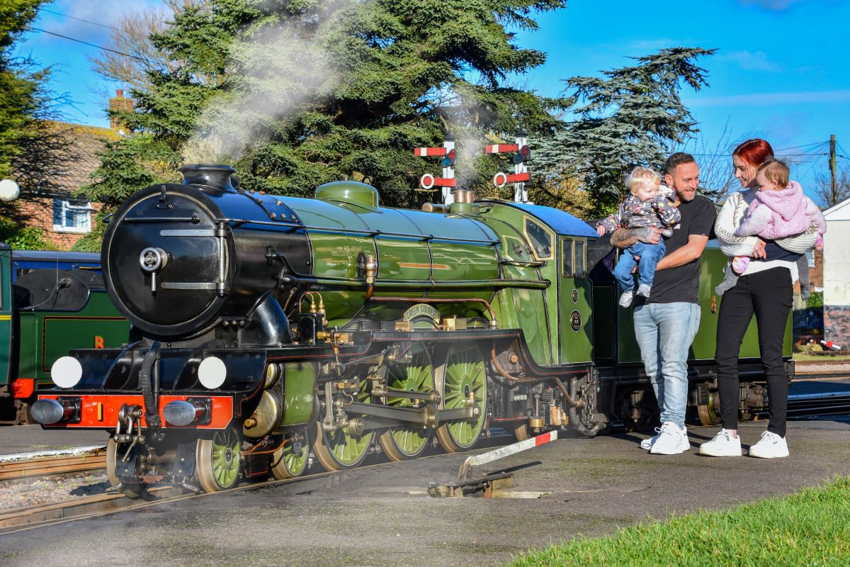 Family looking at Romney, Hythe and Dymchurch Railway steam train