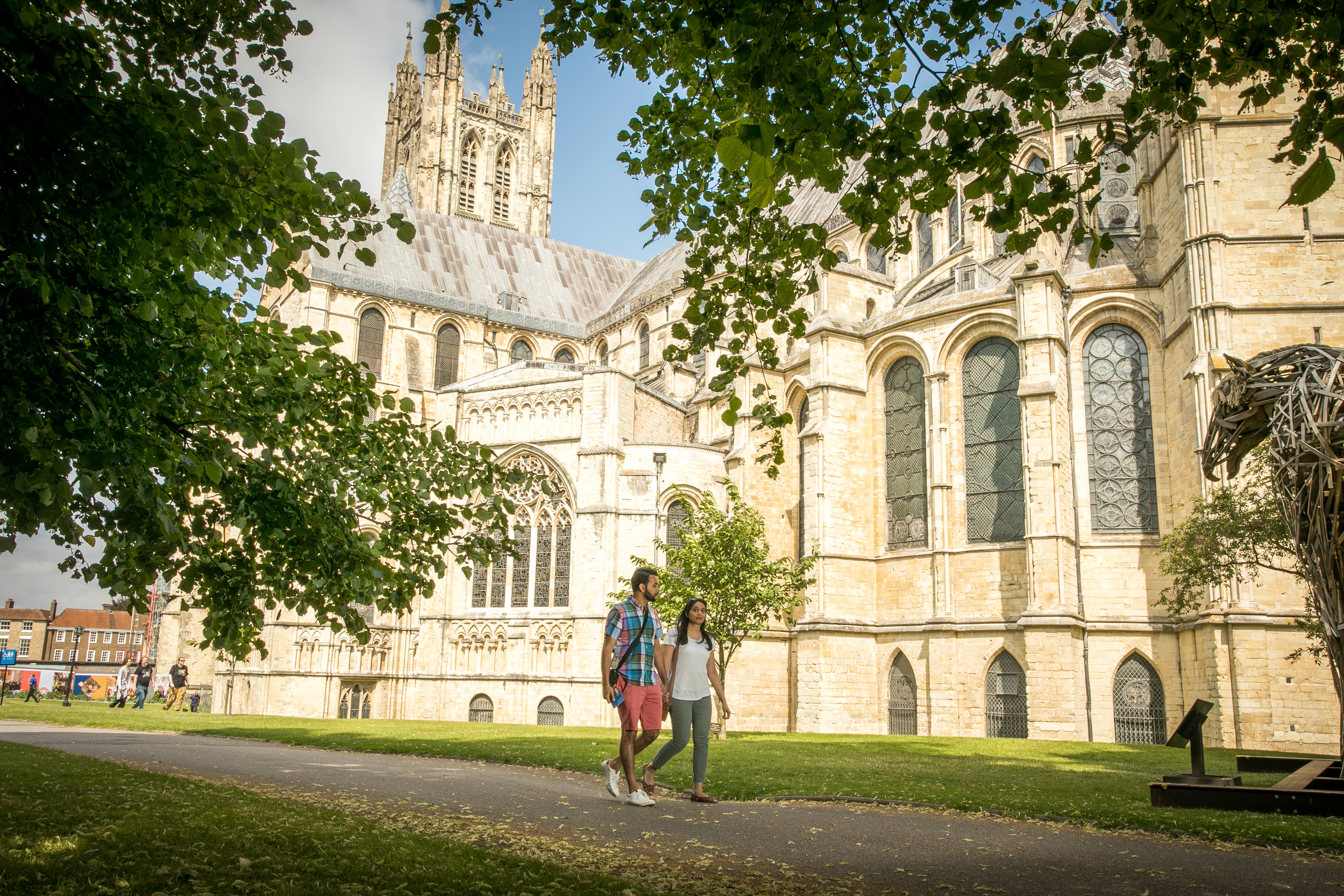 External view of Canterbury Cathedral in summer, couple walking