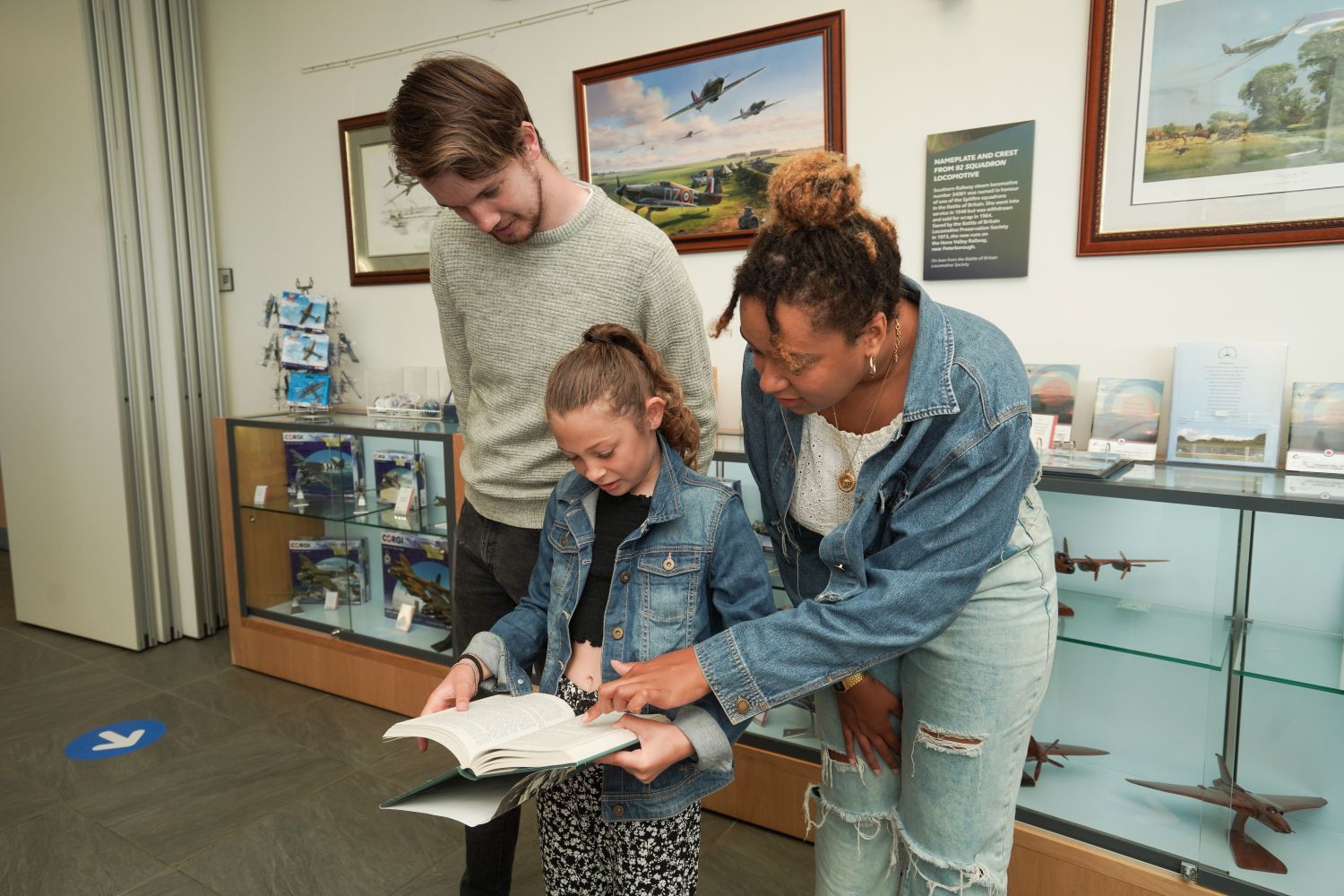 Family looking at book at Battle of Britain Memorial